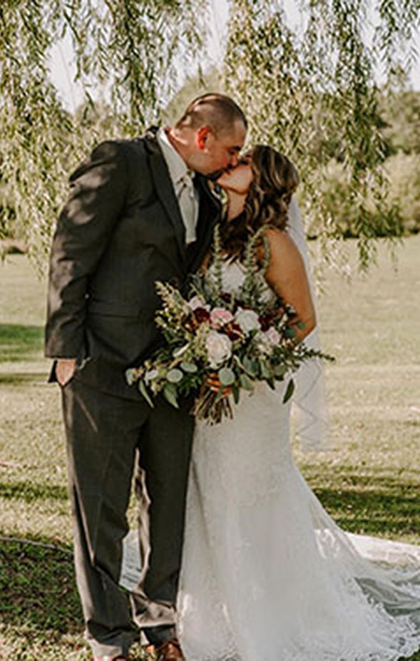 Bride & groom kissing under a tree at Folsom Ridge Ranch